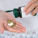 Cropped View of Woman Pouring Pills From Bottle