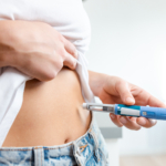 Person administering insulin injection using a pen